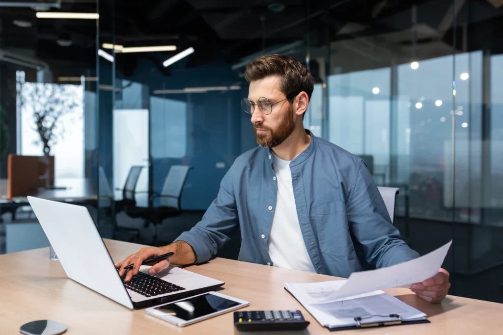 Hombre en una oficina estudiando con un computador